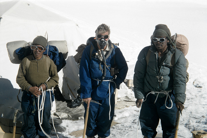 Альпинист Джон Хант накануне покорения Эверста в 1953 году. Рядом его носильщики-шерпы.
